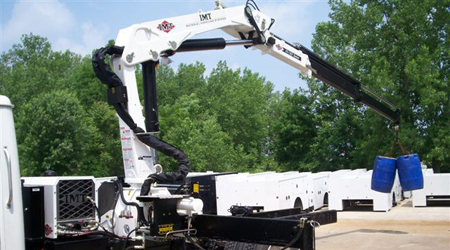 IMT white articulating crane doing a load test truck mounted