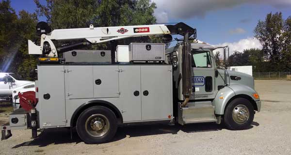 repairs and crane inspections being done on crane truck by service mechanics technians