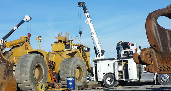 repairs and crane inspections being done on crane truck by service mechanics technians